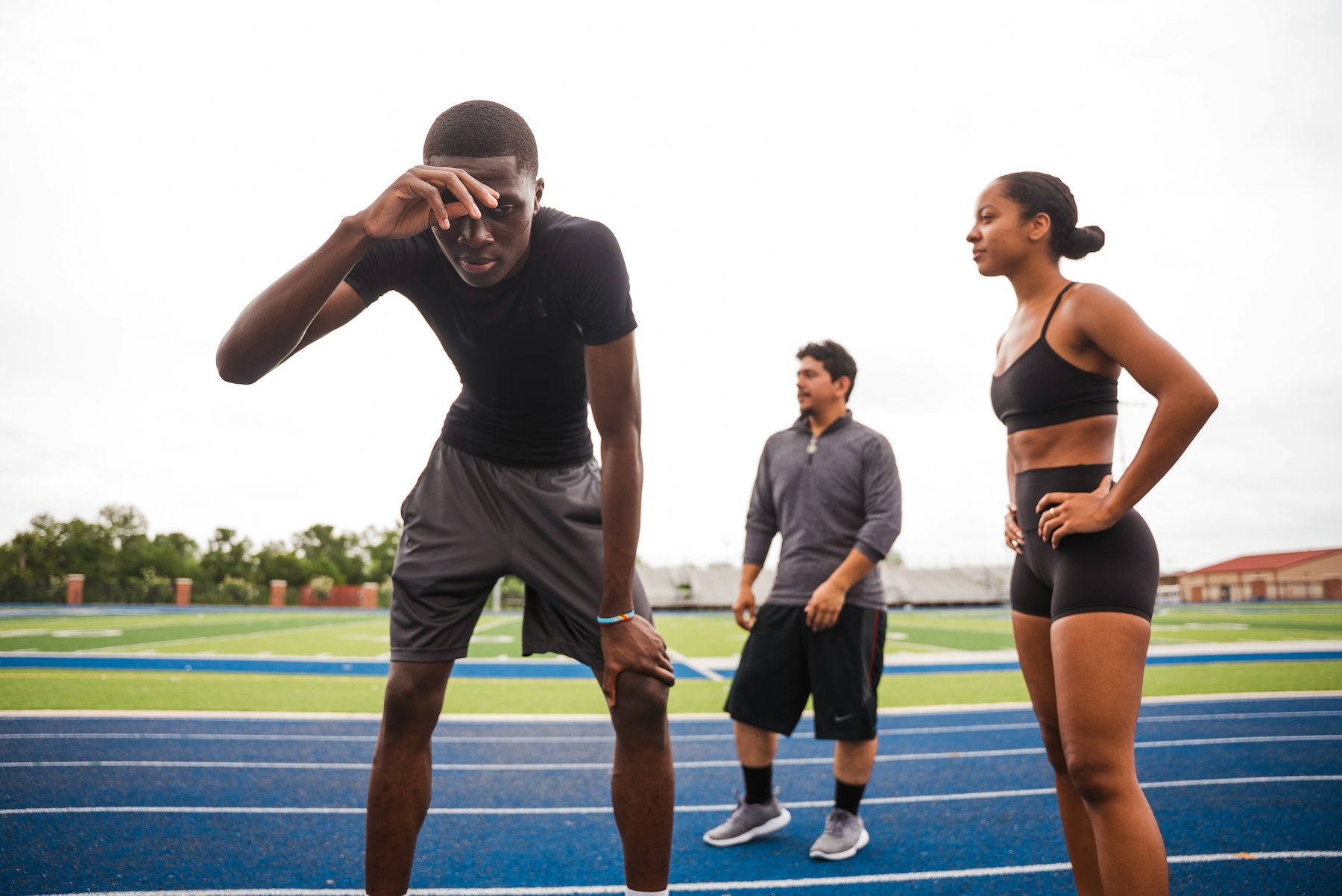 Athletes resting on a running track after training